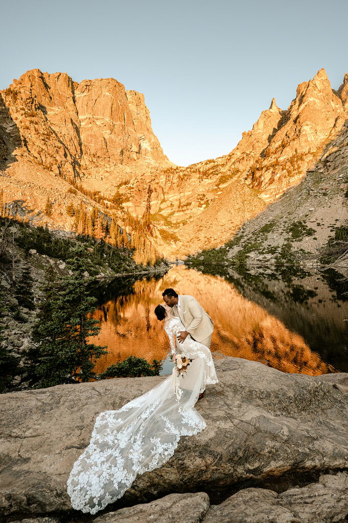 A couple shares a dip kiss in the alpine glow.